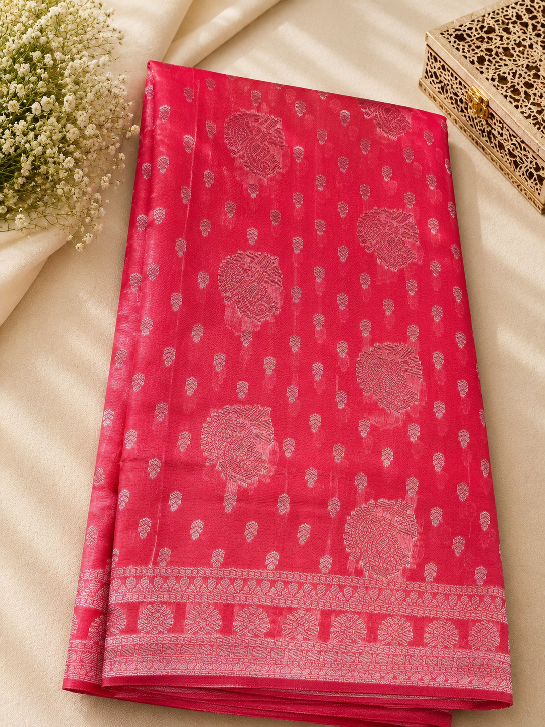 Elegant rani pink saree featuring intricate silver motifs and delicate buttas across the body with silver border