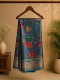 Elegant teal blue saree featuring vibrant multicolor floral prints that add a fresh and graceful charm. Finished with a rich golden woven zari border- Satin Tissue Saree