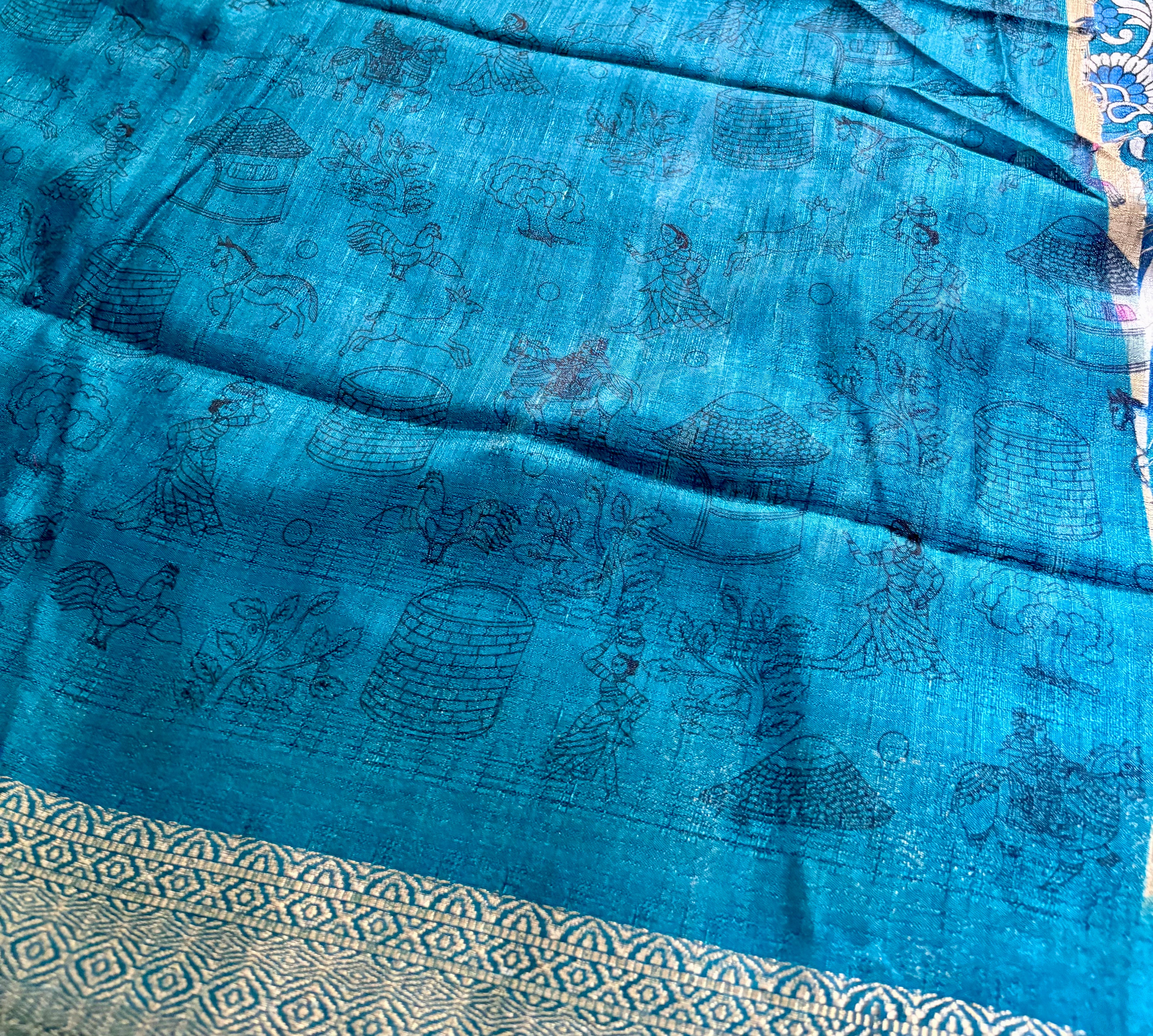 Beautiful Beige Khadi Cotton Saree Featuring vibrant traditional village-life and art prints with Rich Blue zari woven border.