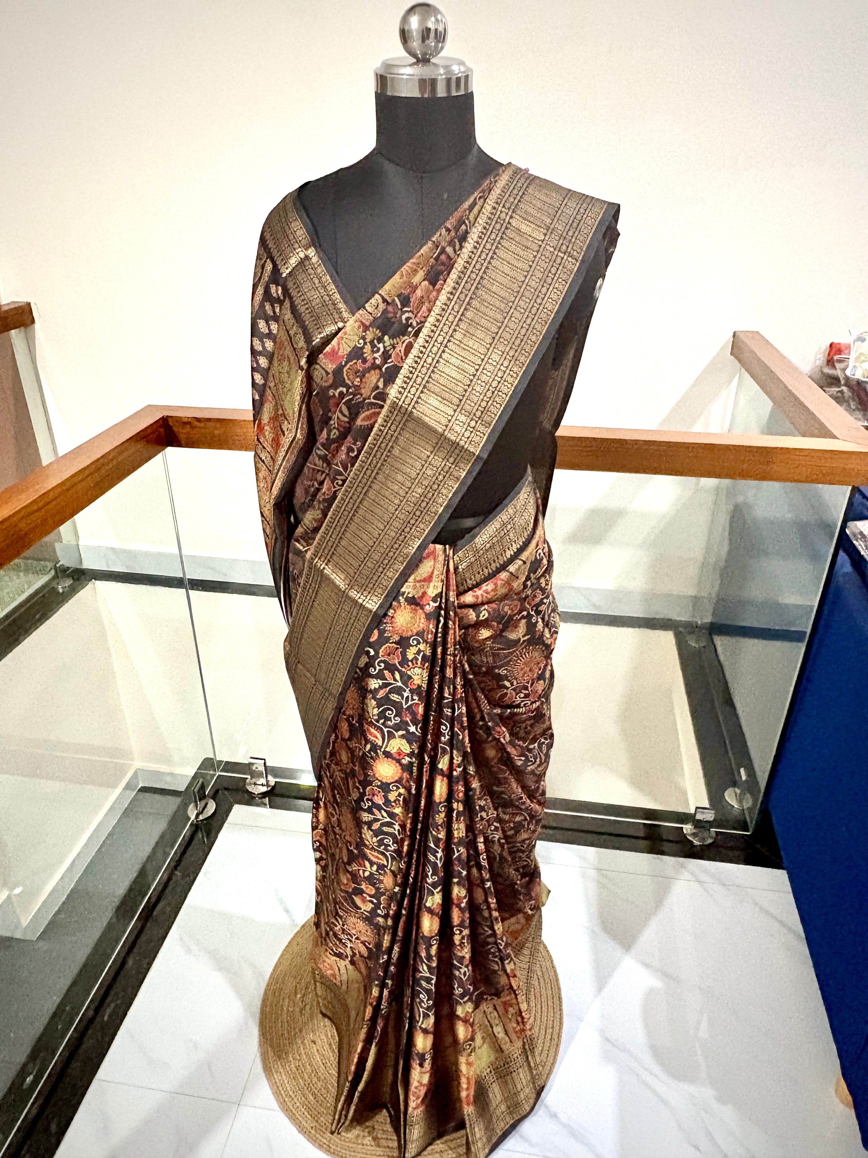 Elegant Saree Featuring a Rich Black Base with Incricate Floral and Motifs in Warm Gold, Rust and Beige Tones with Antique Gold Zari Weaving Border.