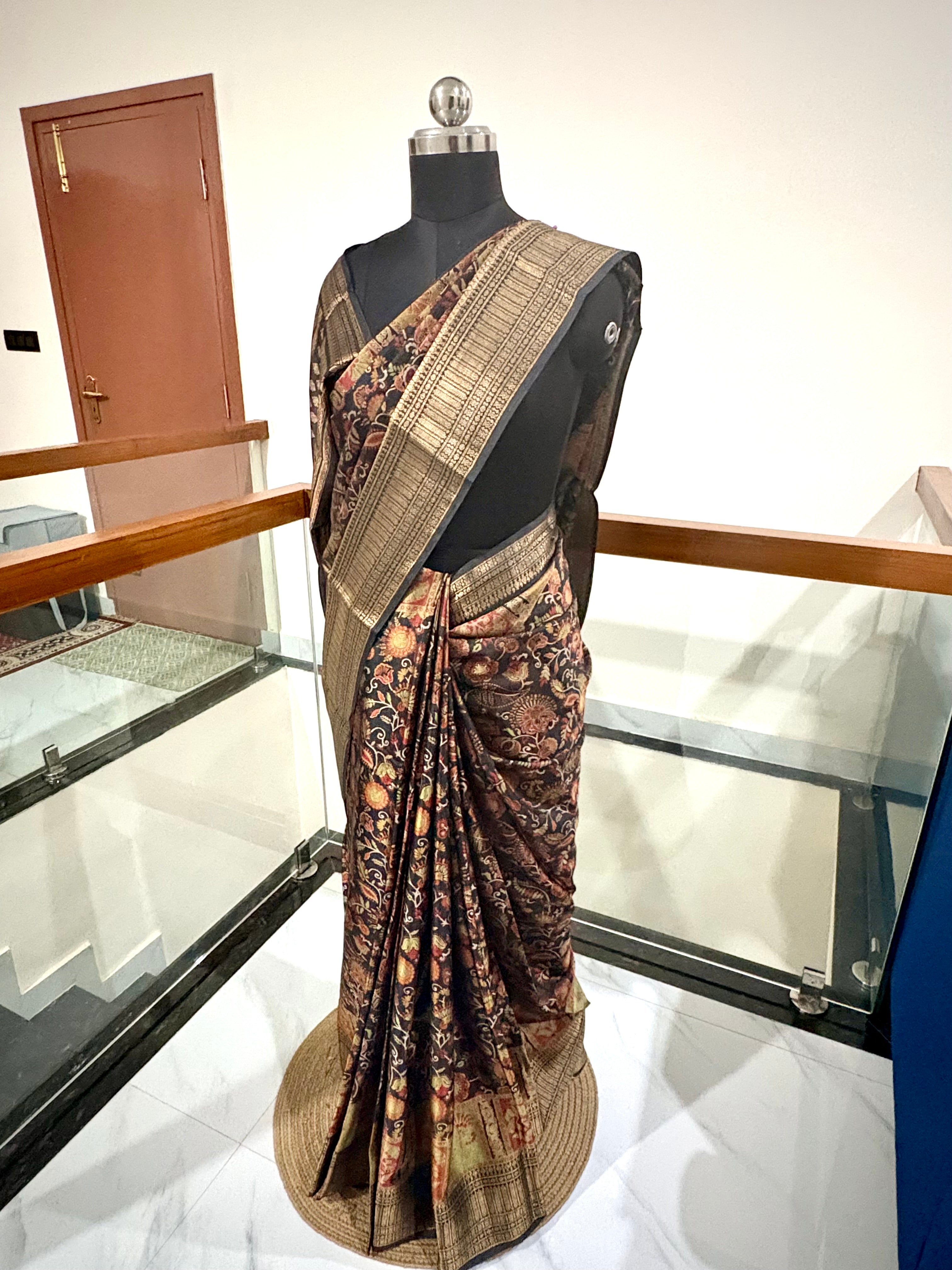 Elegant Saree Featuring a Rich Black Base with Incricate Floral and Motifs in Warm Gold, Rust and Beige Tones with Antique Gold Zari Weaving Border.