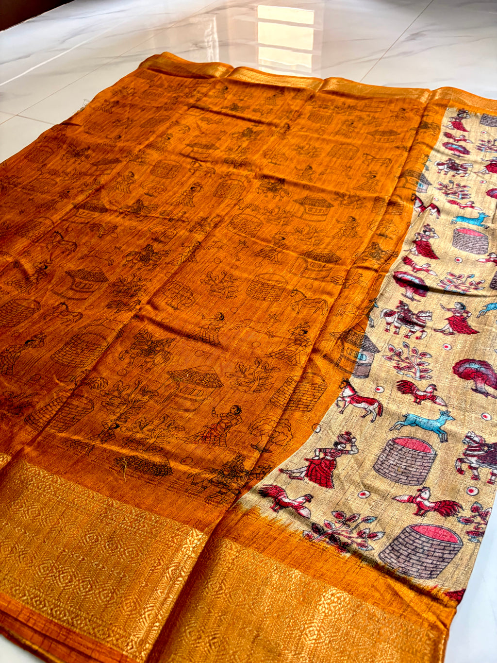 Beautiful Beige Khadi Cotton Saree Featuring vibrant traditional village-life and folk art prints with Rich golden zari woven border