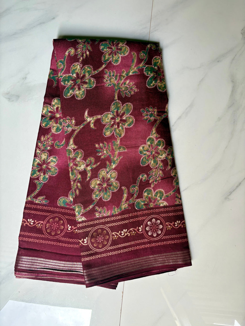 Elegant maroon saree featuring graceful floral vine prints in contrasting green tones and silver zari line border- Cotton silk soft Saree