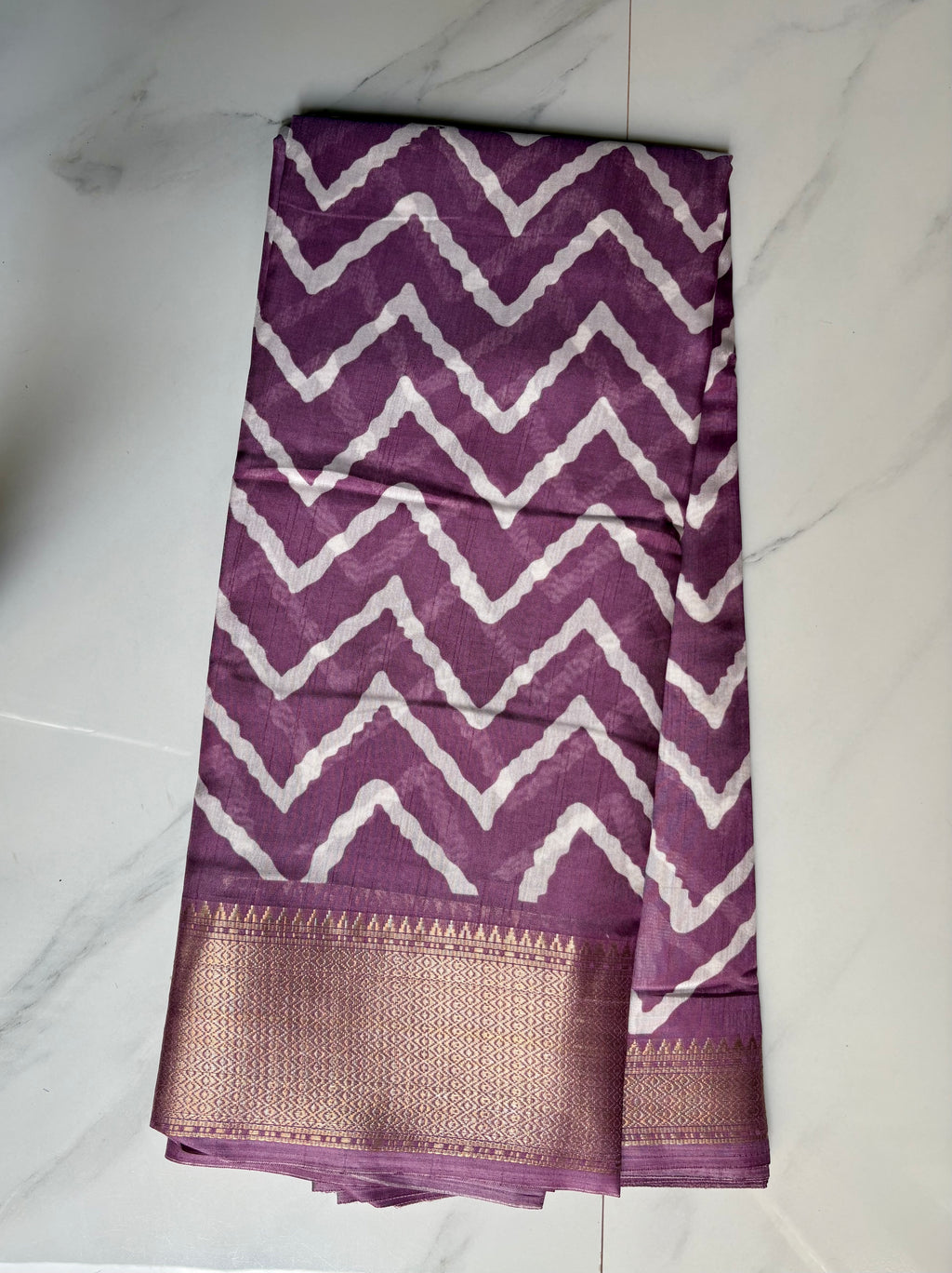 Elegant purple printed saree featuring bold white zigzag patterns and a rich zari border - Cotton tissue soft Saree