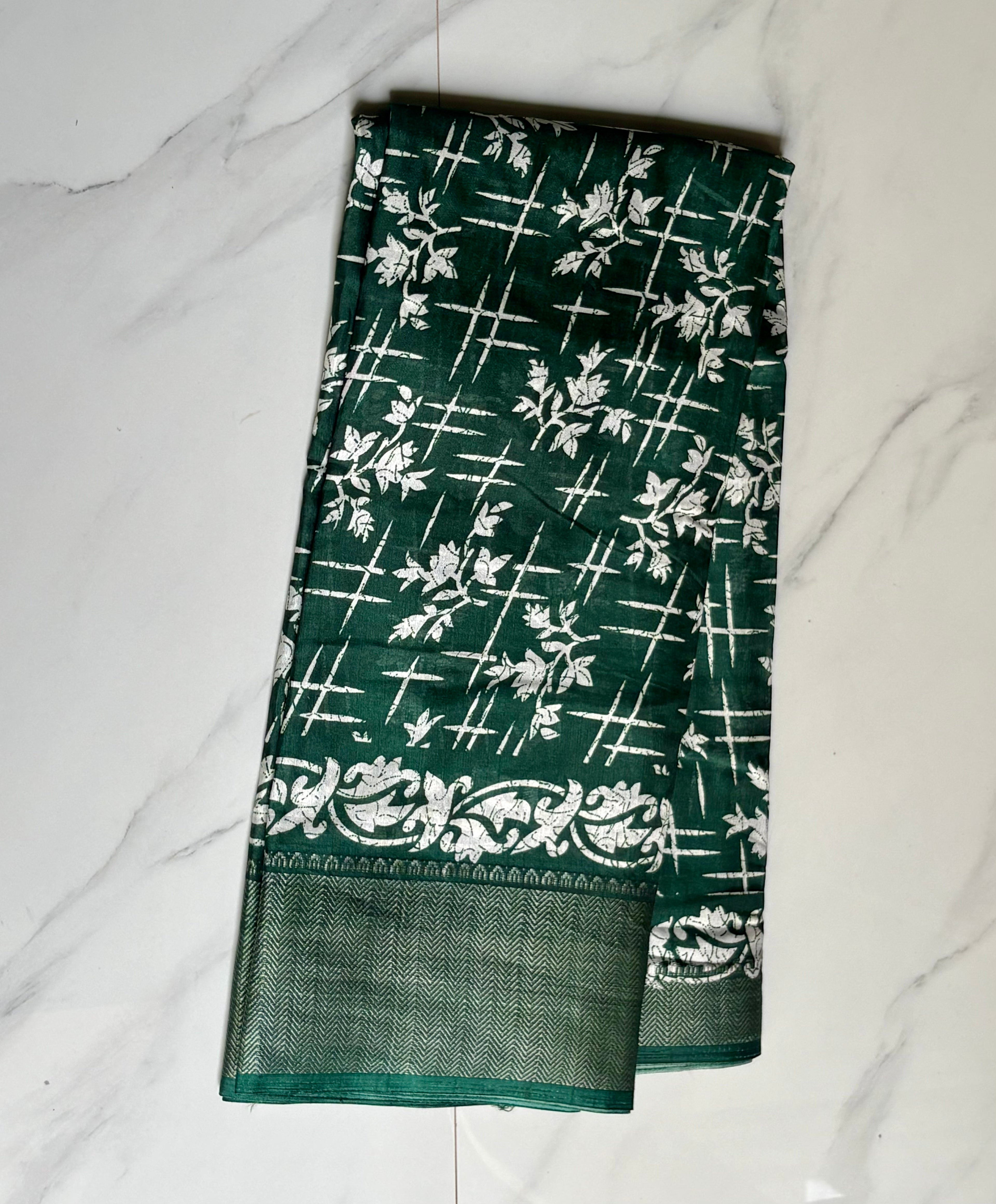 Elegant bottle green saree features a graceful white floral and abstract print and a beautifully Zari border - Cotton tissue soft Saree