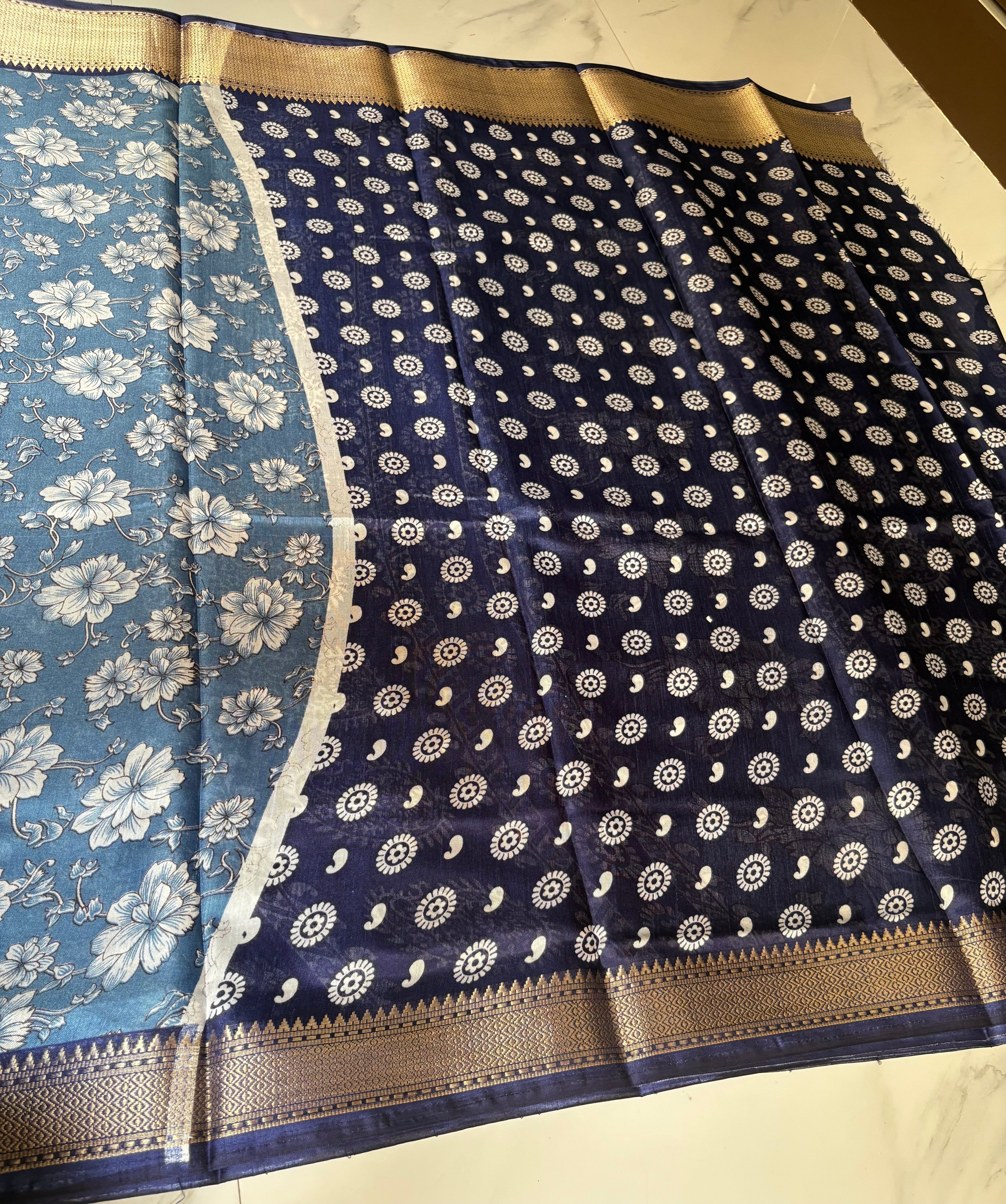 Elegant blue floral printed saree, beautifully adorned with delicate white blossom motifs and complemented by a rich navy blue zari border- Cotton tissue soft Saree