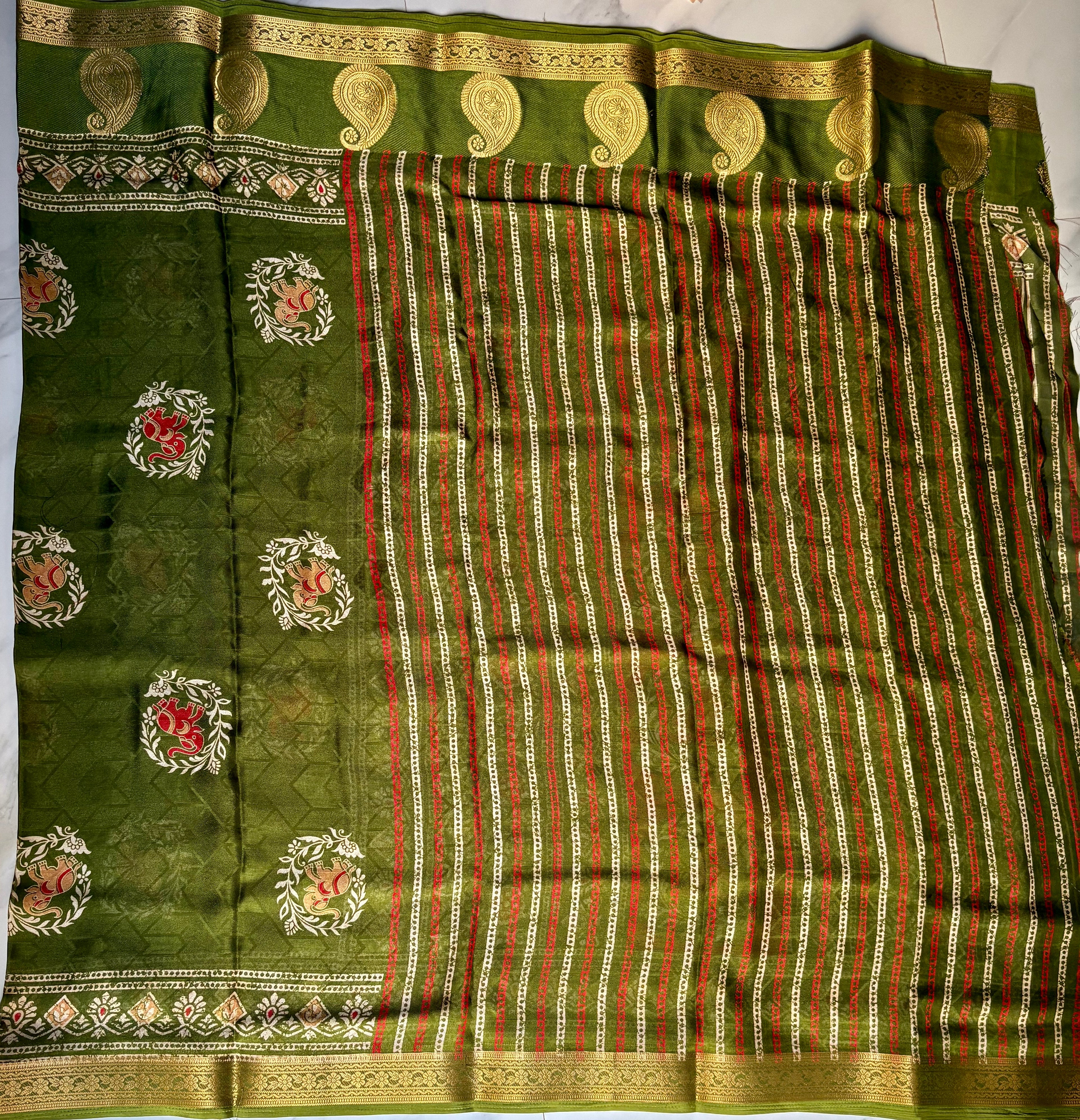 Elegant olive green shade, this saree features elephant motifs with delicate floral accents and a rich golden zari woven border - Foil Georjjett jacquard Saree