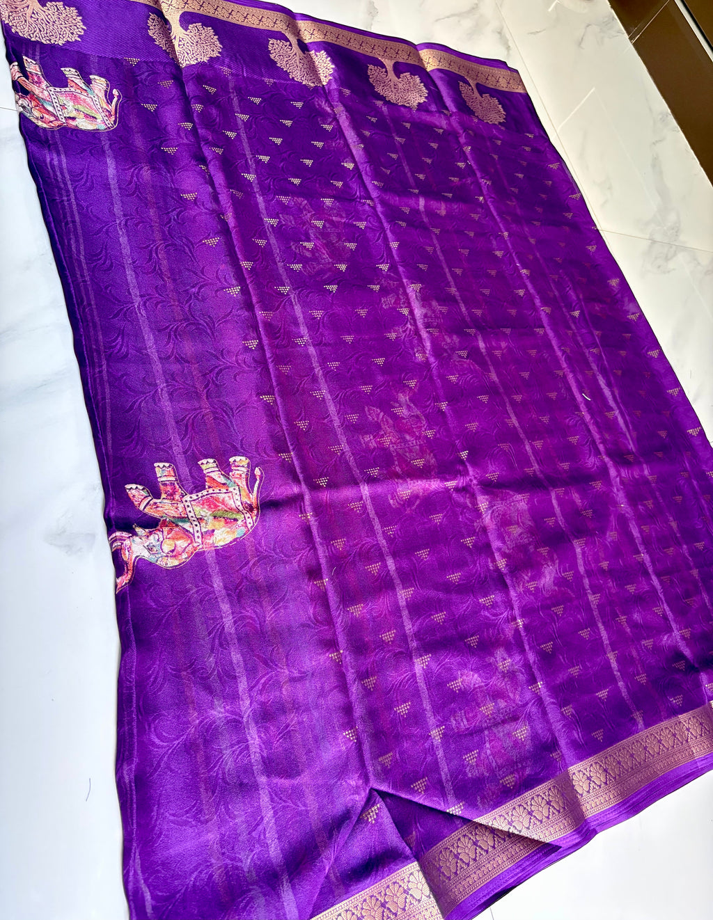 Elegant purple saree featuring elephant and tree motifs that reflect traditional artistry the rich golden woven border- Foil Georjjett jacquard Saree