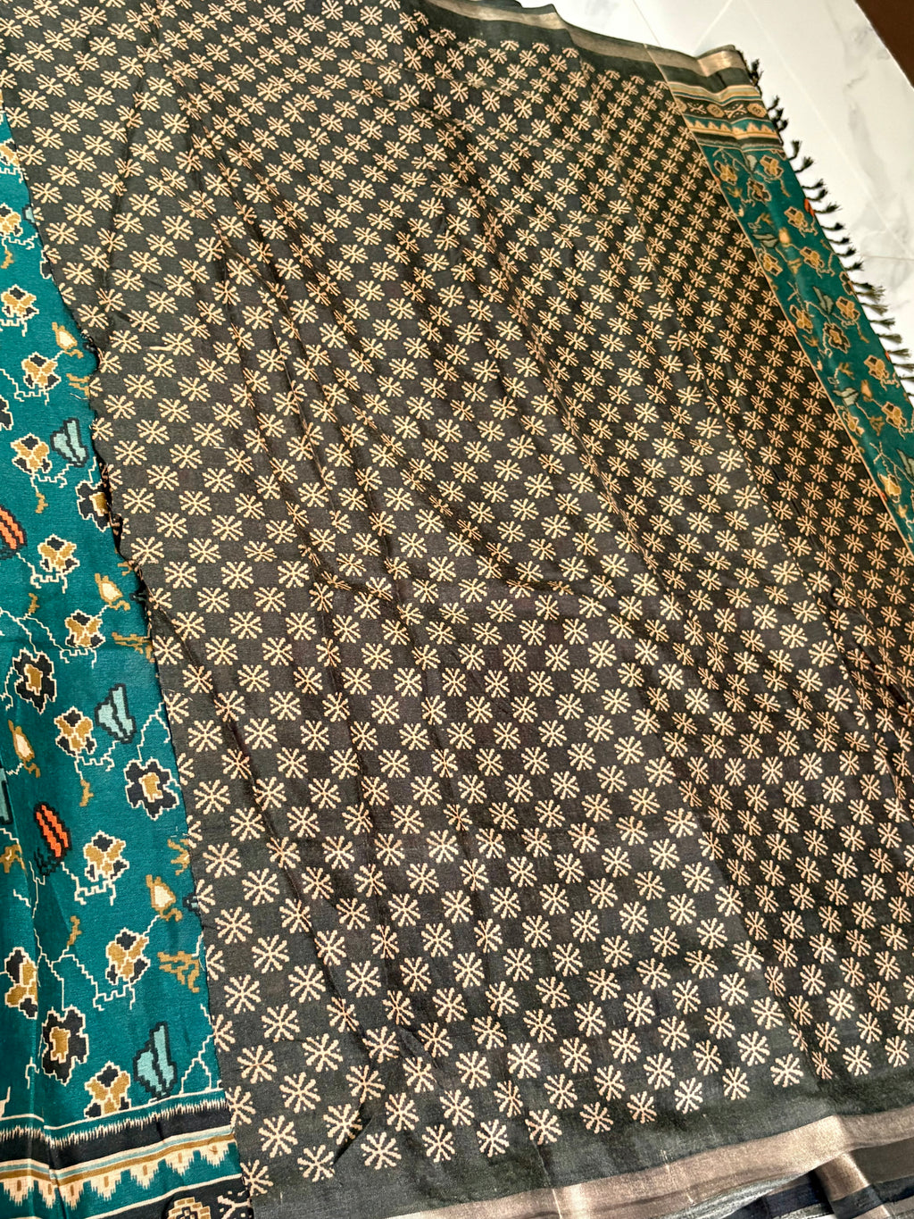 Elegant teal green saree featuring charming floral prints and a beautiful contrast Zari line border.