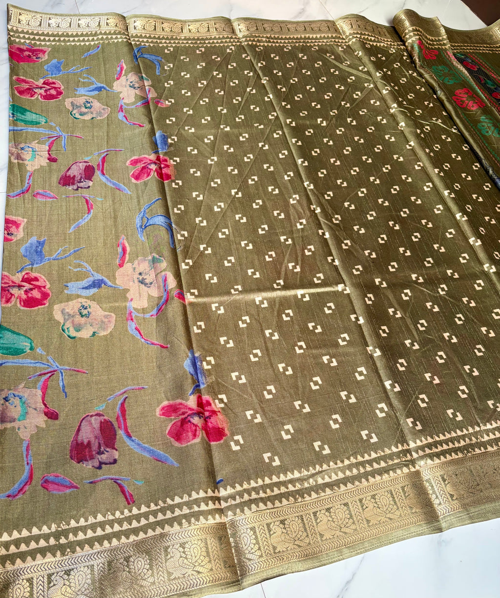 Elegant olive green saree featuring vibrant multicolor floral prints that add a fresh and graceful appeal. Finished with a rich golden woven border. - Satin Tissue Saree