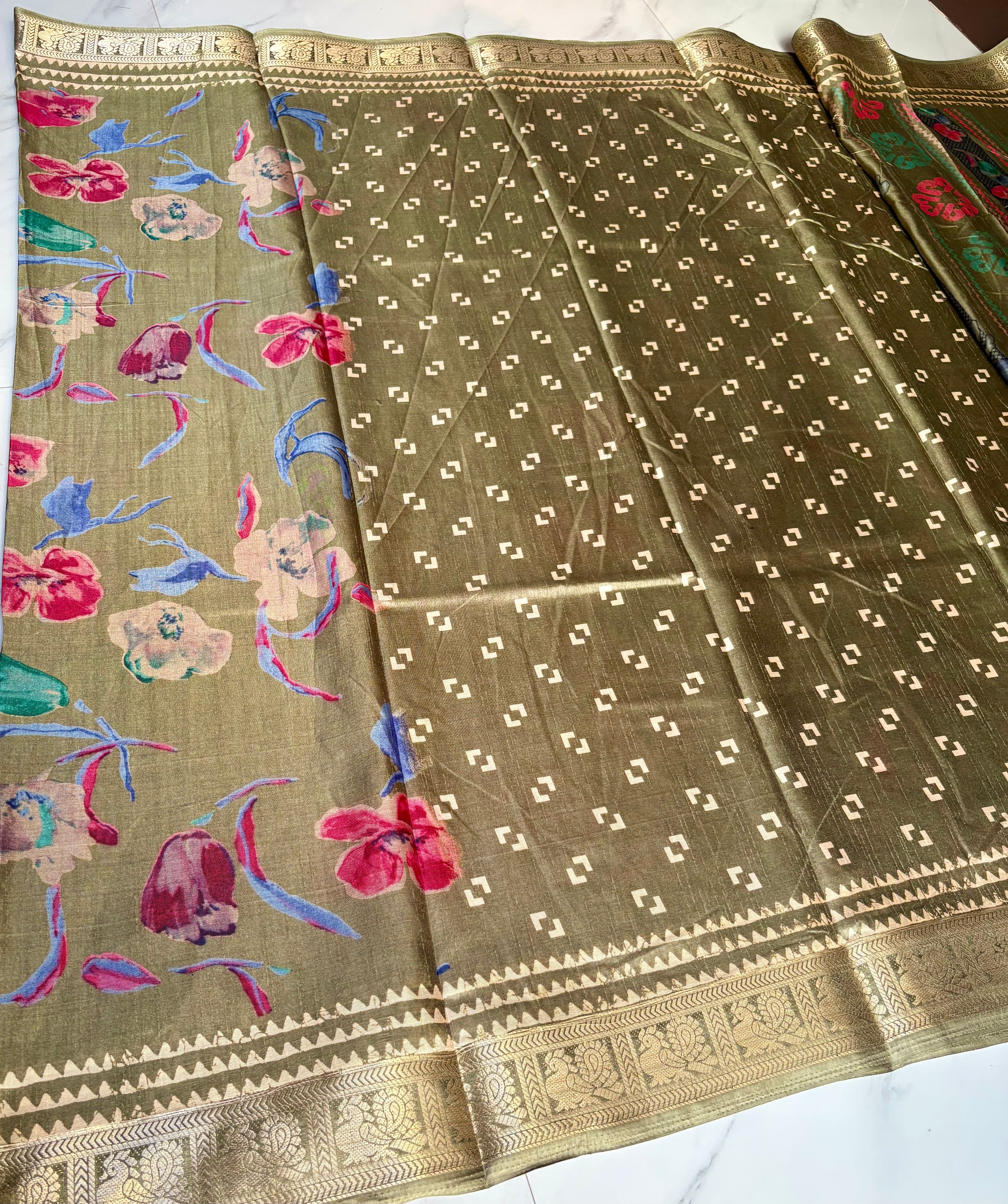 Elegant olive green saree featuring vibrant multicolor floral prints that add a fresh and graceful appeal. Finished with a rich golden woven border. - Satin Tissue Saree