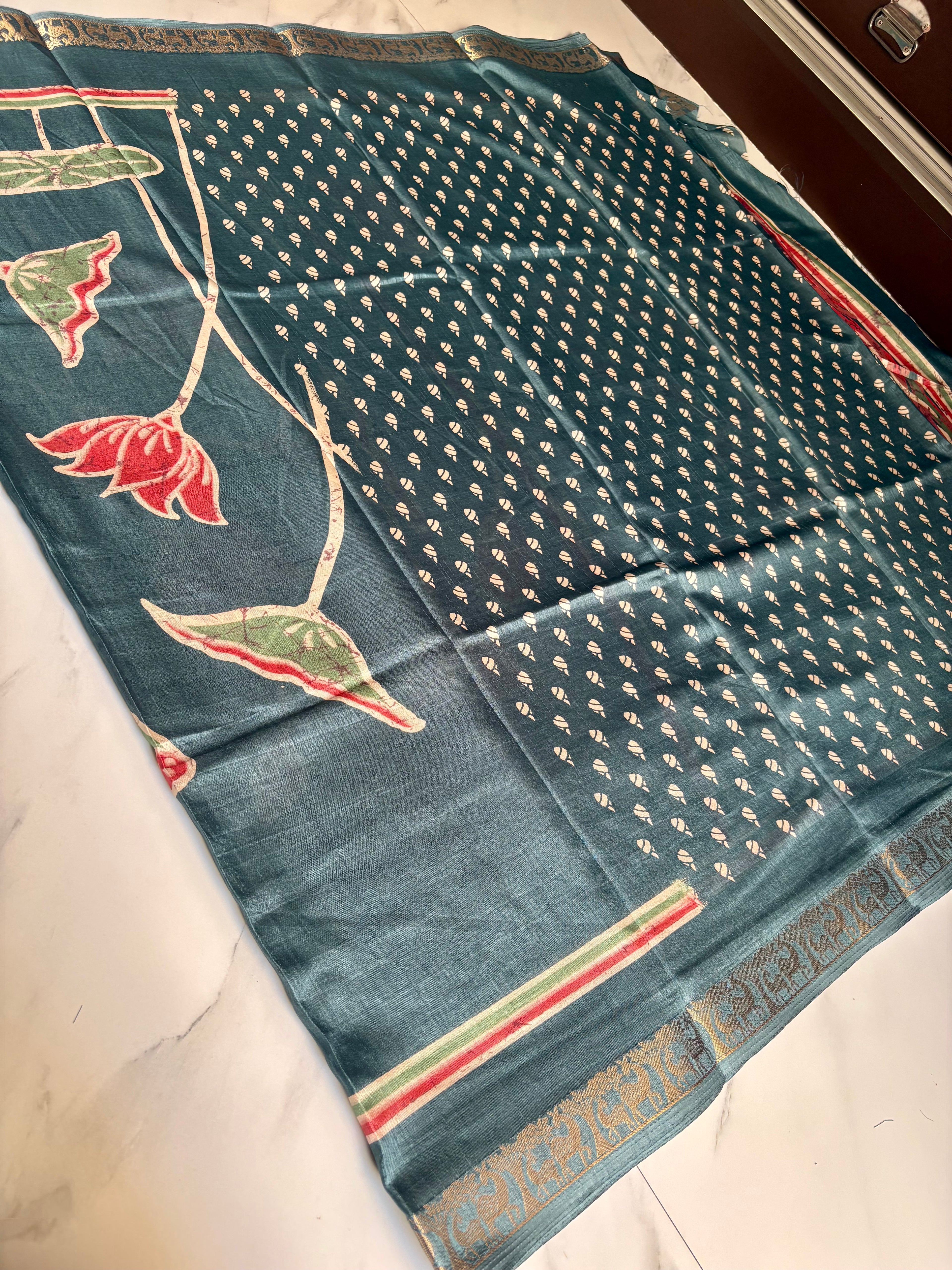 Elegant teal blue saree featuring a graceful lotus floral print with a beautifully woven golden elephant motif border - Satin Tissue Saree