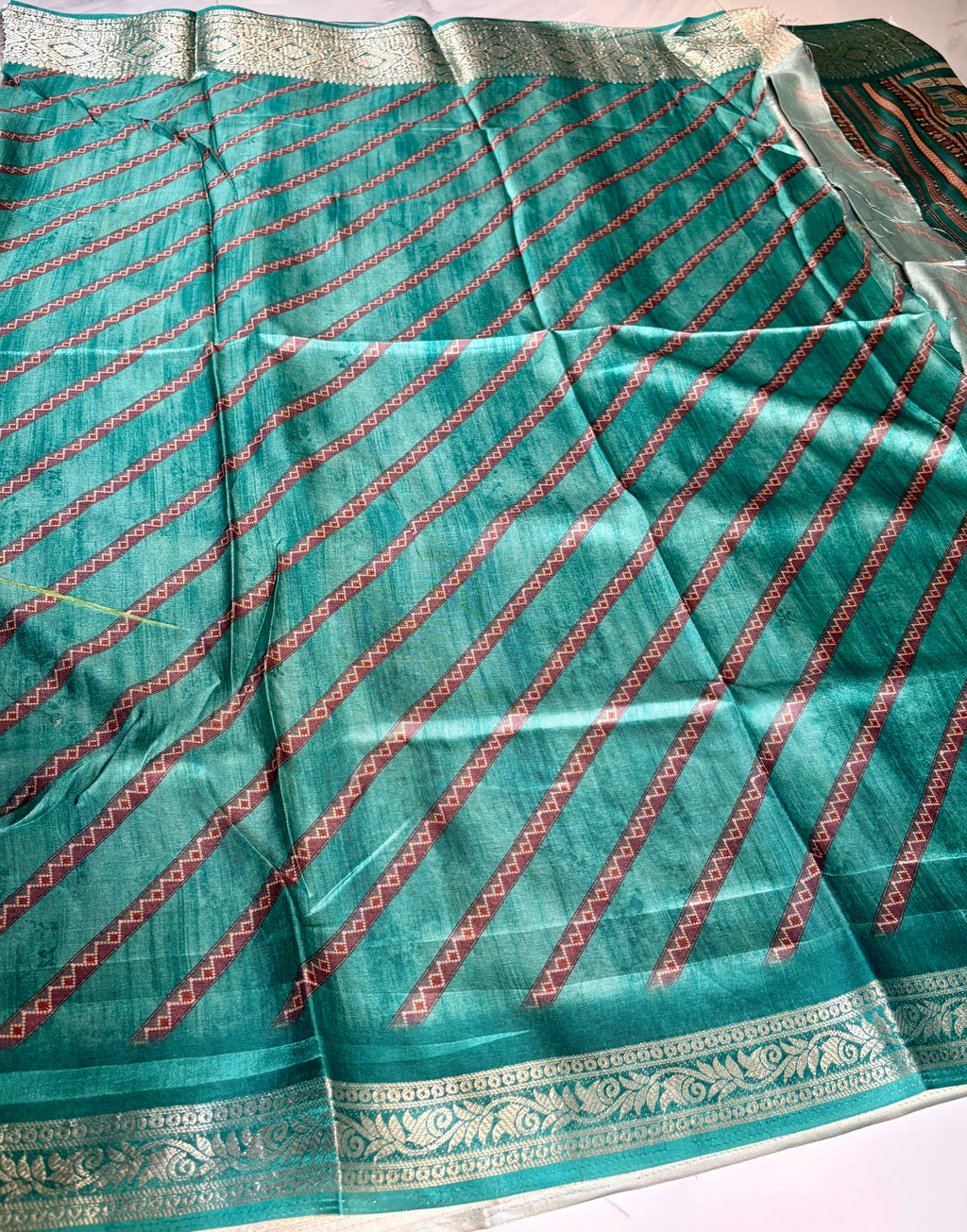 Elegant teal green printed saree featuring intricate heritage-inspired patchwork designs with rich woven zari border - Satin Tissue Saree