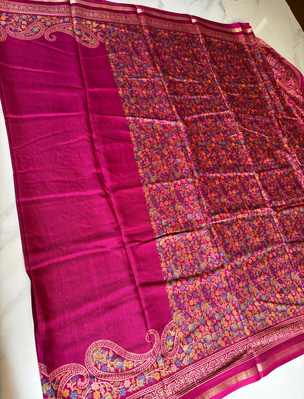 Elegant magenta pink saree featuring a rich plain body with a beautifully embroidered paisley floral border and subtle golden edging.