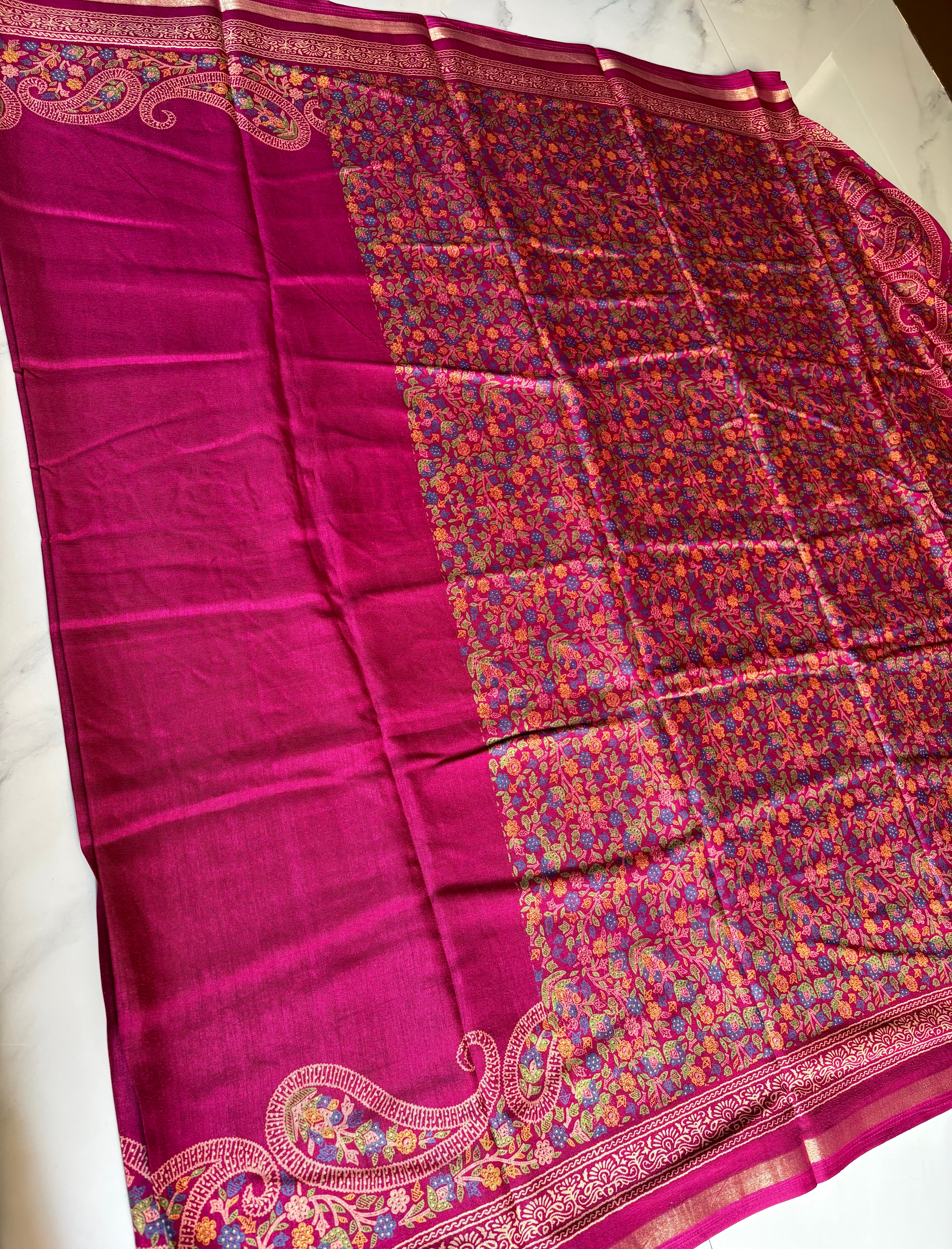 Elegant magenta pink saree featuring a rich plain body with a beautifully embroidered paisley floral border and subtle golden edging.