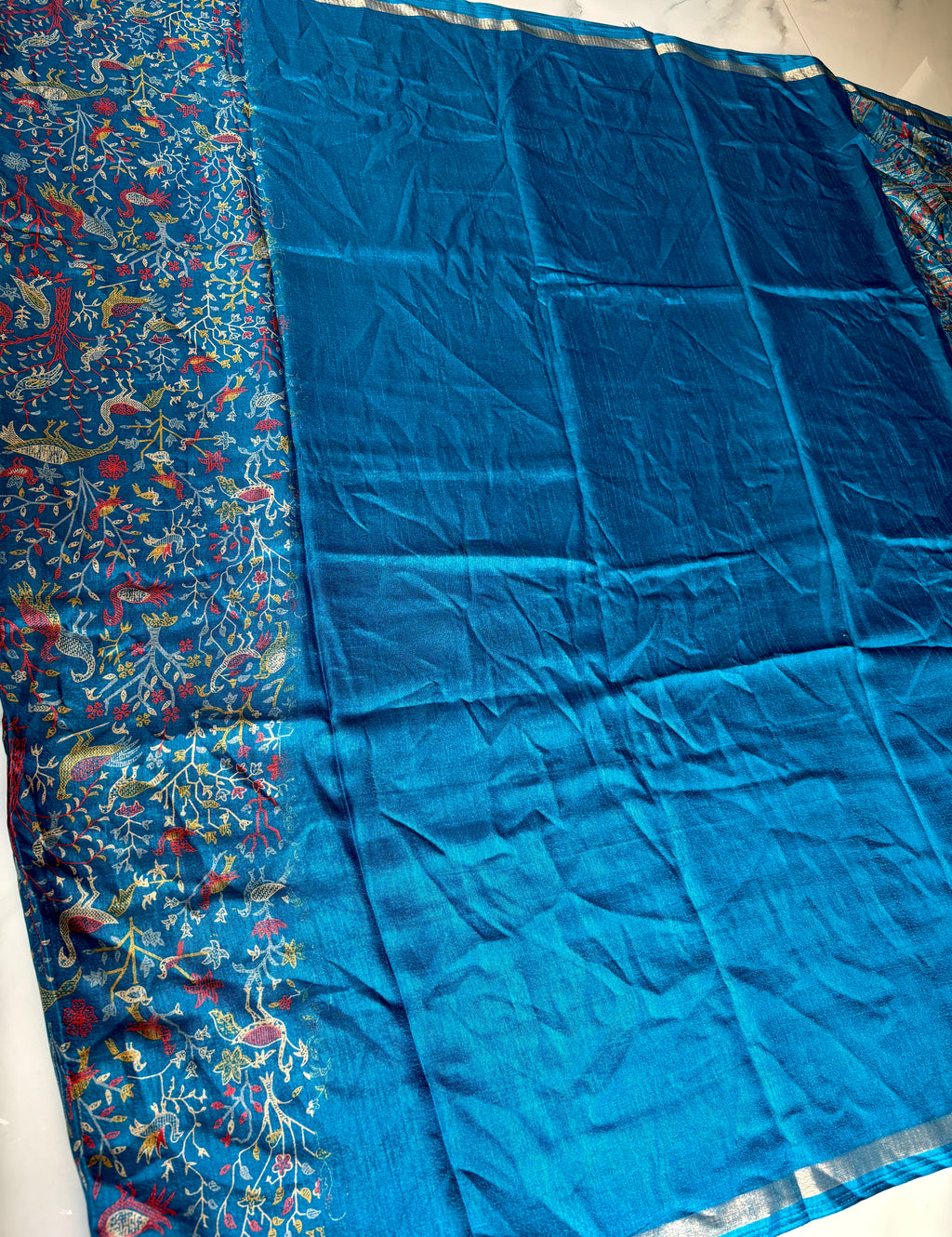 Elegant royal blue saree featuring an intricate all-over nature-inspired print and subtle Silver edging.