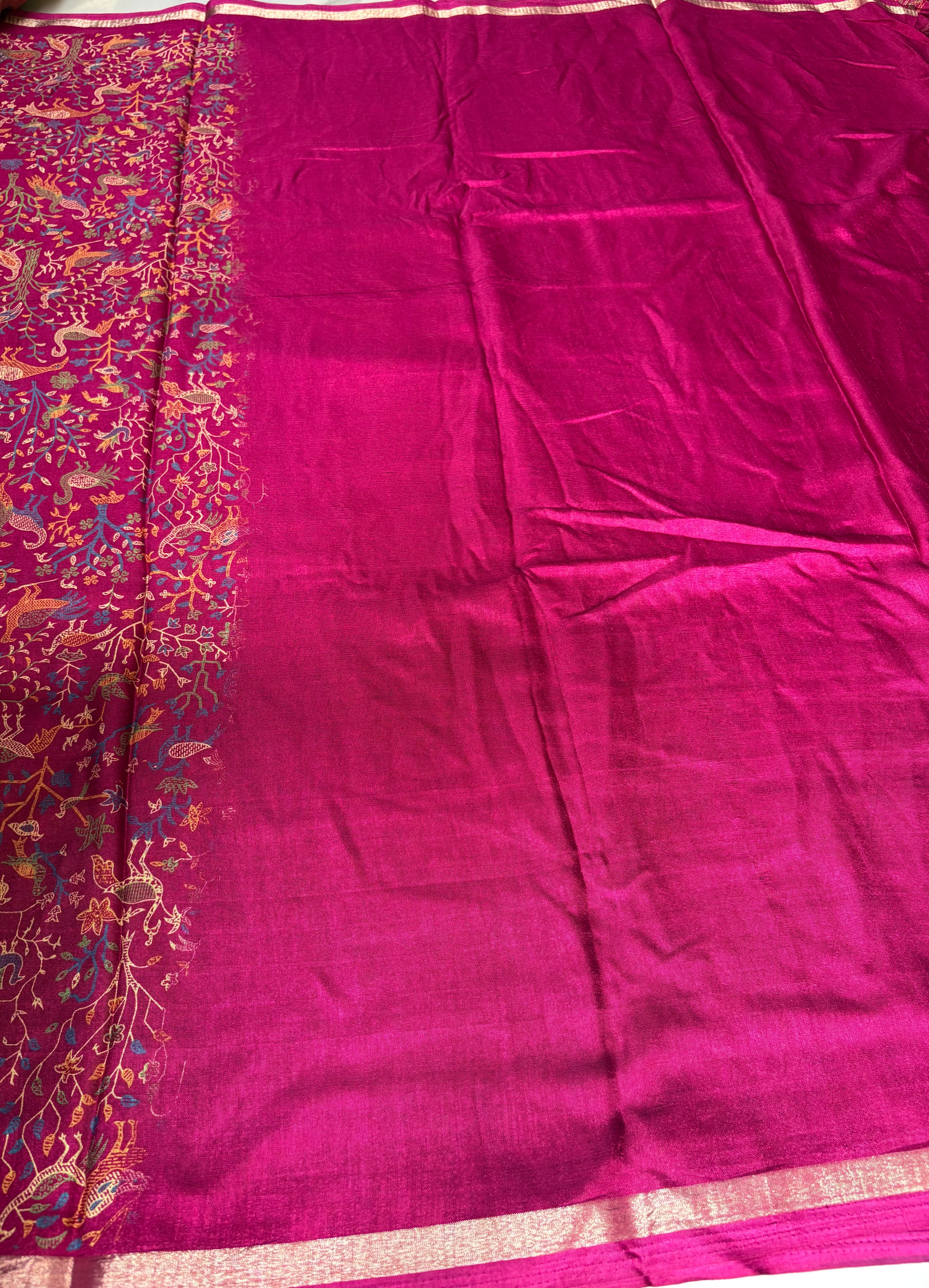 Elegant magenta saree featuring intricate nature-inspired bird and floral prints and subtle golden edging.