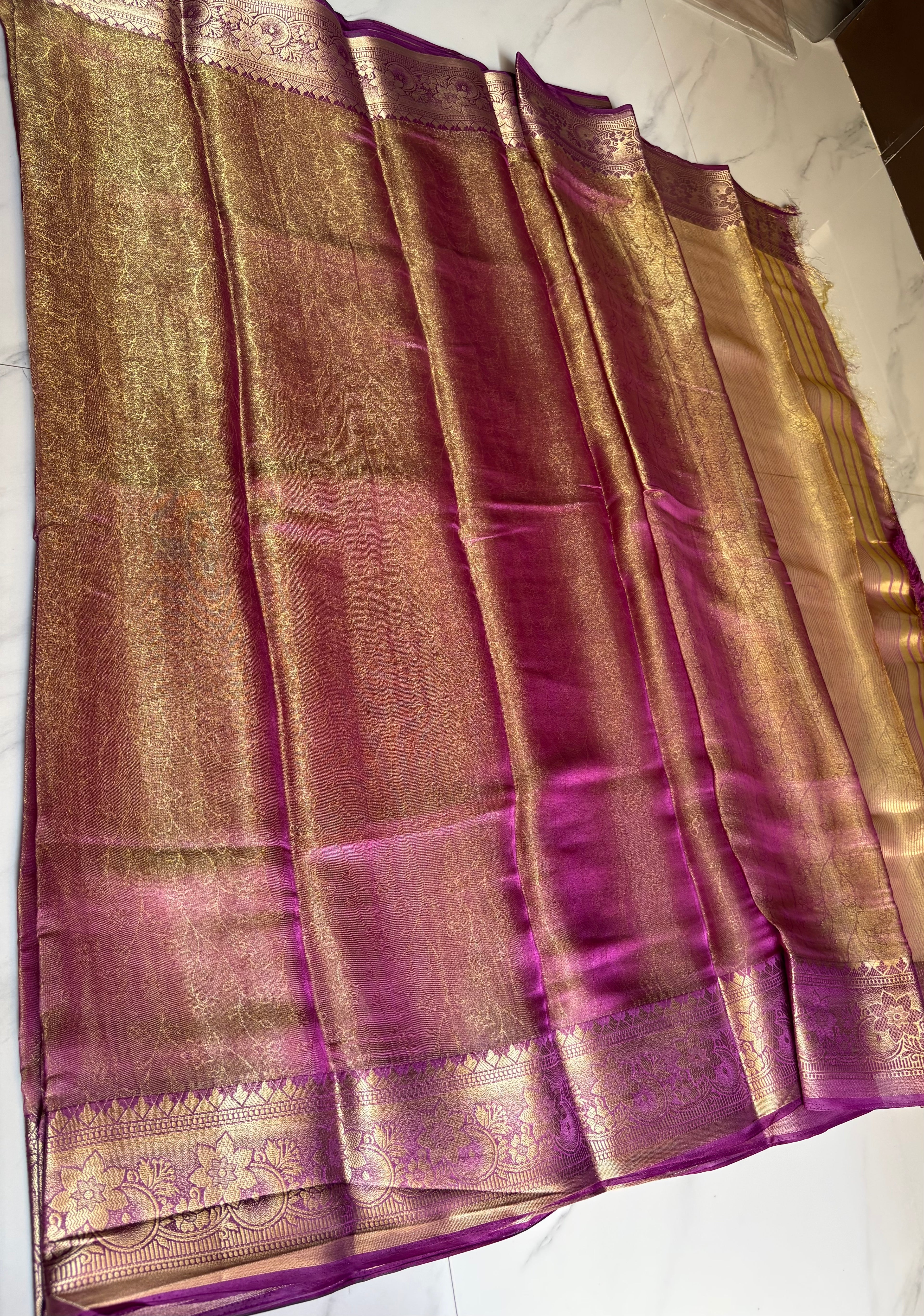 Elegant with this stunning magenta - Gold Tissue saree, beautifully enhanced by a rich zari weave.