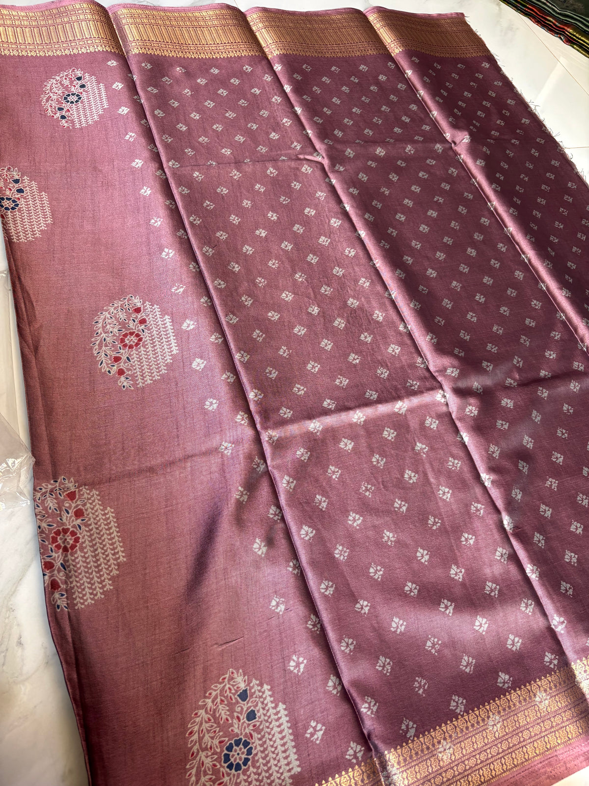 Graceful mauve saree, adorned with delicate floral woven motifs and a rich golden zari border.
