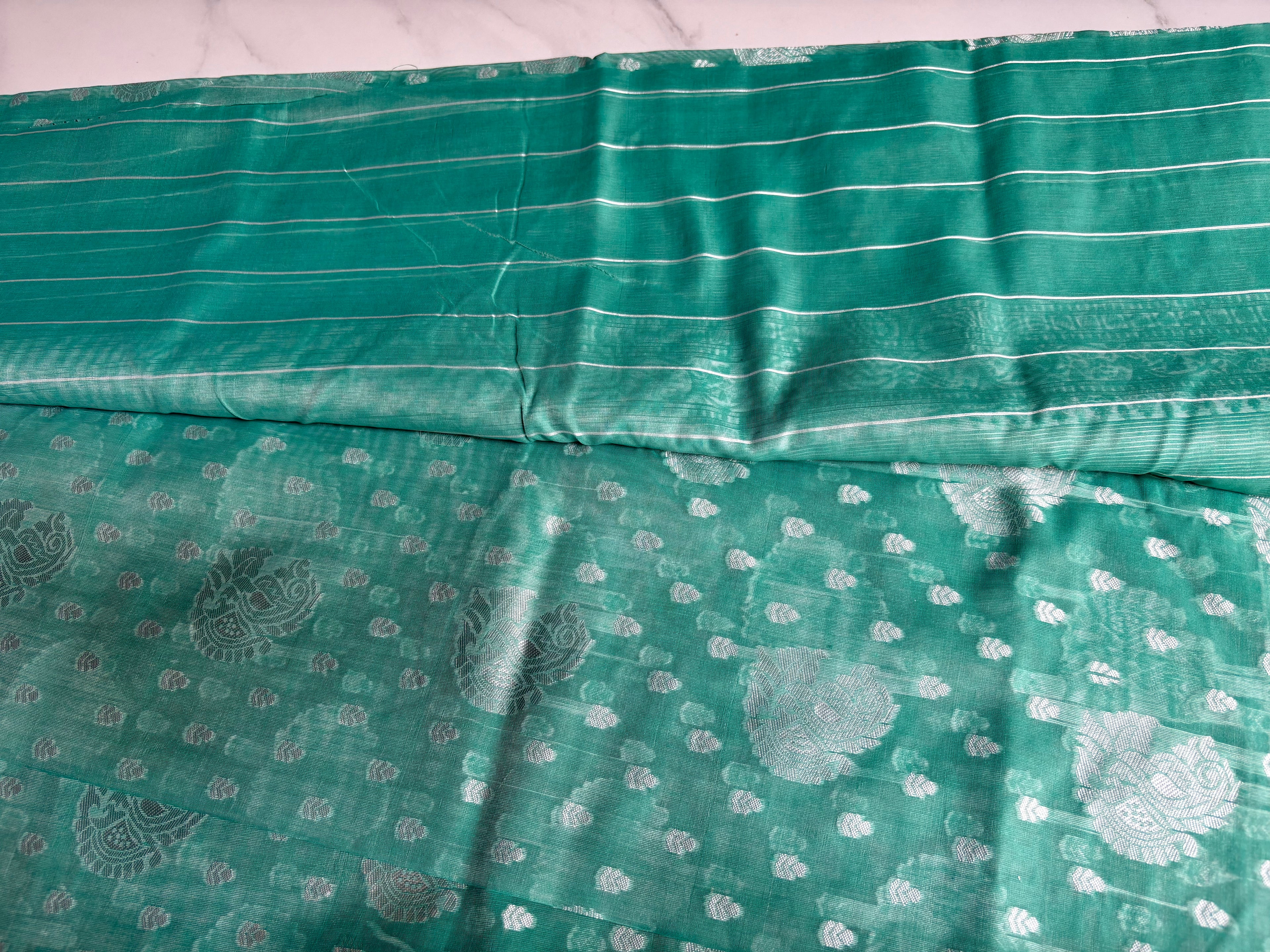 Elegant teal green Cotton saree featuring intricate silver paisley motifs and delicate detailing with silver border