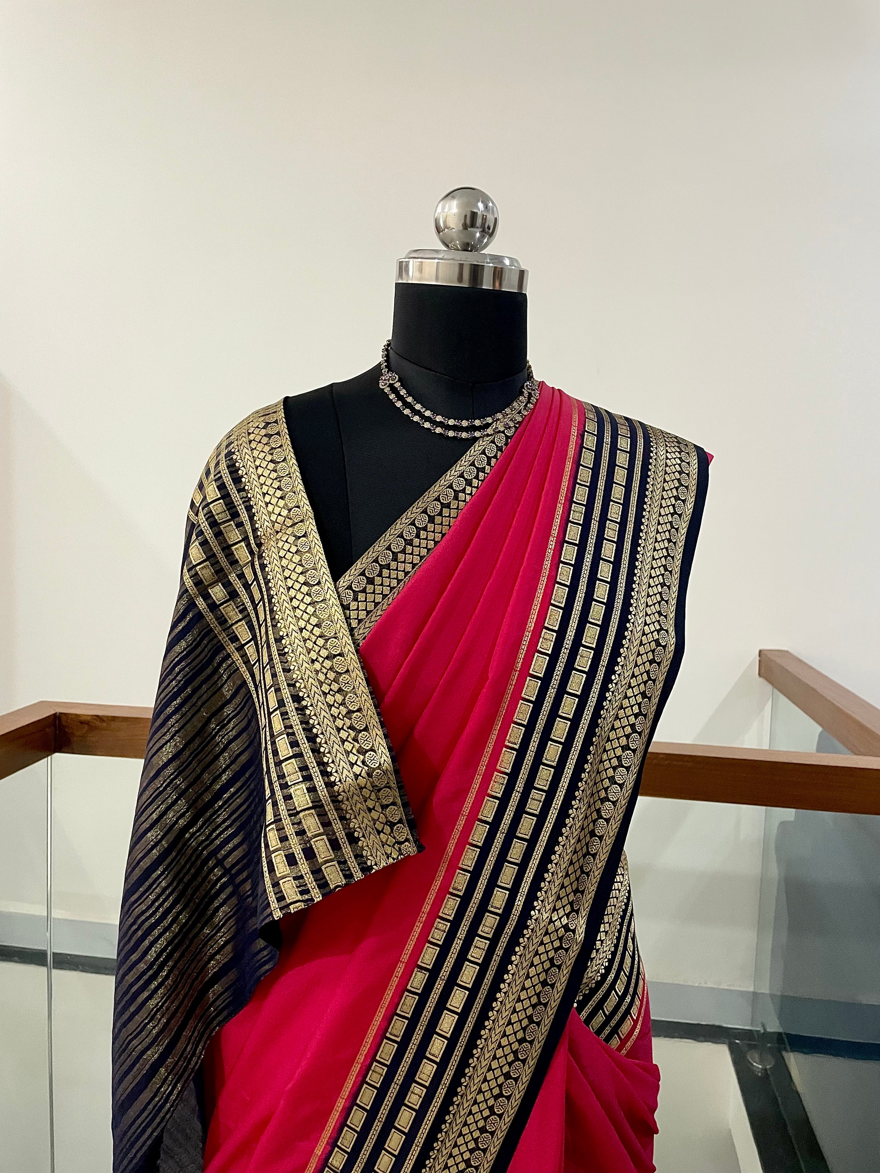 Beautiful Crepe Silk Saree with Striking Combination Of Bright Pink with a rich Navy Blue and gold border, giving it a Regal and Elegant look.