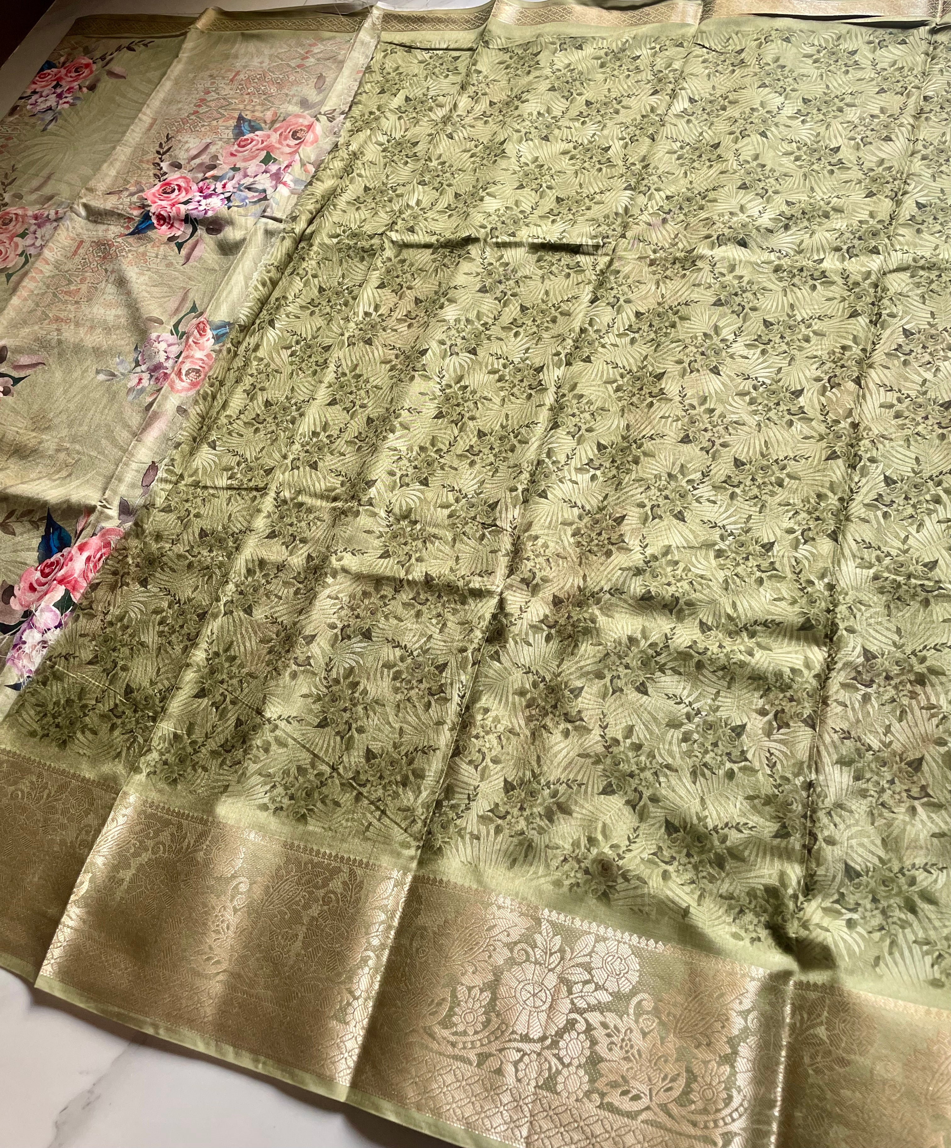 Elegant sage green saree featuring a graceful floral print in soft pink and lavender hues with rich woven zari border - Satin Tissue Saree (Copy)