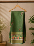 Graceful olive green saree, adorned with delicate floral motifs and heritage-inspired scenic border. Accented with intricate golden zari.